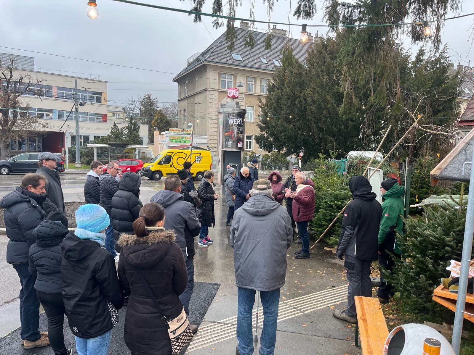 Segnung der Christbäume am 8. Dezember am Verkaufsplatz, umringt von Kundinnen und Kunden